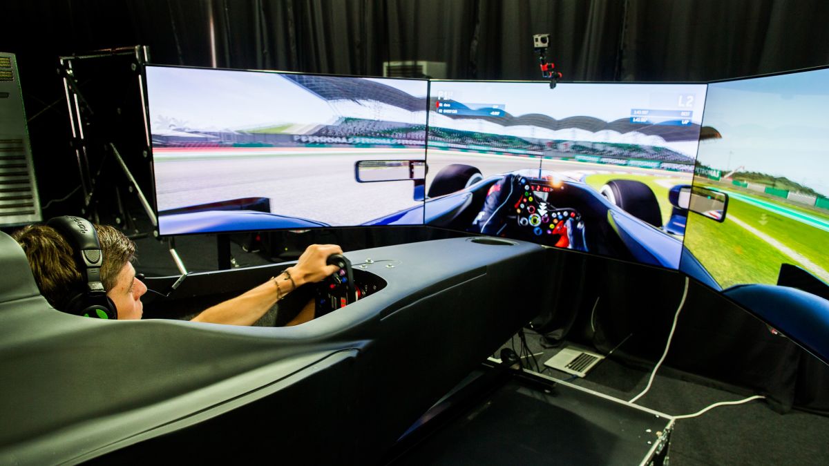 person driving racing simulator